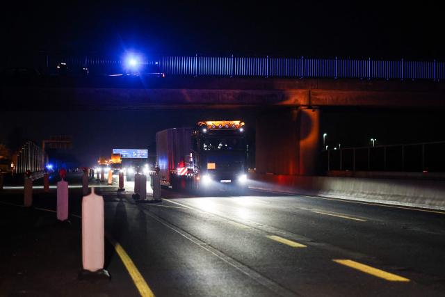 The truck carrying a Castor container for high-level radioactive waste is escorted by police vehicles as it drives on the A3 motorway in Bottrop, western Germany, on March 25, 2026. (Photo by Christoph Reichwein / dpa pool / AFP)