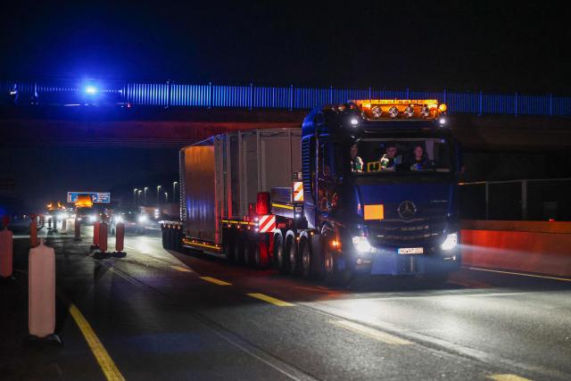 The truck carrying a Castor container for high-level radioactive waste is escorted by police vehicles as it drives on the A3 motorway in Bottrop, western Germany, on March 25, 2026. (Photo by Christoph Reichwein / dpa pool / AFP)