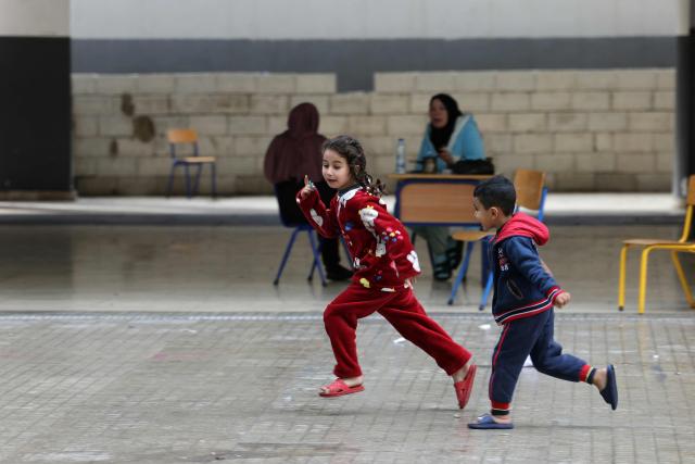 Displaced Lebanese children play in the playground of a public school that has been converted into a shelter in the town of Dekwaneh, north of Beirut on March 25, 2026. Lebanon was pulled into the Middle East war when the Tehran-backed Hezbollah militant group began firing rockets into Israel on March 2 to avenge the killing of Iran's supreme leader on February 28 by the US and Israel. Israel has since launched strikes across Lebanon, killing at least 1,039 people and displacing more than a million others in more than three weeks of fighting. It has also sent ground troops into the country's south. (Photo by Anwar AMRO / AFP)