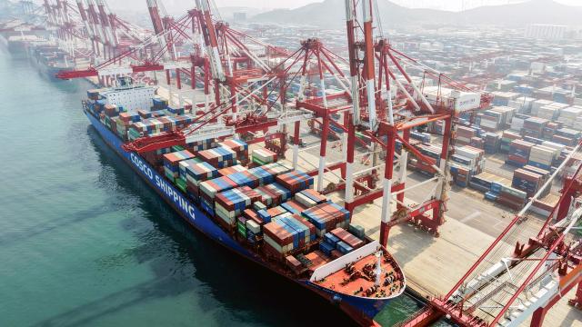 A cargo ship operated by Cosco Shipping is docked at the foreign trade container terminal of Qingdao Port, operated by Shandong Port Group, in China's eastern Shandong province on March 25, 2026. Chinese shipping giant Cosco said on March 25 that it was resuming new bookings for container shipments to some Gulf countries, after a three-week suspension in response to the Middle East war. (Photo by CN-STR / AFP) / China OUT
