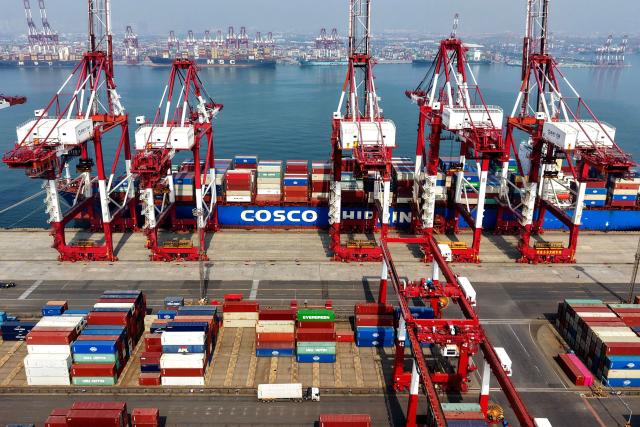 A cargo ship operated by Cosco Shipping is docked at the foreign trade container terminal of Qingdao Port, operated by Shandong Port Group, in China's eastern Shandong province on March 25, 2026. Chinese shipping giant Cosco said on March 25 that it was resuming new bookings for container shipments to some Gulf countries, after a three-week suspension in response to the Middle East war. (Photo by CN-STR / AFP) / China OUT