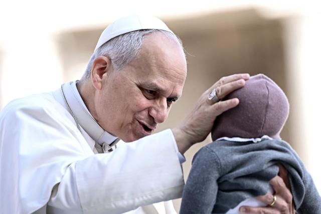 Pope Leo XIV blesses a baby during the weekly general audience at St Peter's Square in The Vatican on March 25, 2026. (Photo by Filippo MONTEFORTE / AFP)