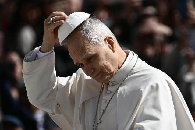 Pope Leo XIV adjusts his skull cap during the weekly general audience at St Peter's Square in The Vatican on March 25, 2026. (Photo by Filippo MONTEFORTE / AFP)