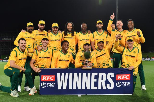 South Africa's Keshav Maharaj (front 3rd R) holds the series trophy as he and his teammates pose after winning the fifth Twenty20 international cricket match between New Zealand and South Africa at Hagley Oval in Christchurch on March 25, 2026. (Photo by Sanka Vidanagama / AFP)