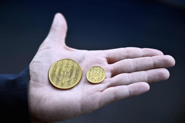 This photograph shows a 300 euro coin and a 75 euro coin during the presentation of the 'Belga Gold', a Belgian investment coin, in Brussels on March 25, 2026. (Photo by ERIC LALMAND / Belga / AFP) / Belgium OUT