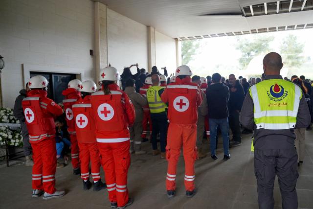 Mourners and members of the Lebanese Red Cross take part in the funeral of two first aid responders they day after they were killed in an Israeli airstrike, in the southern city of Nabatieh on March 25, 2026. Israel's attacks in Lebanon have killed more than 1,000 people, according to Lebanon's health ministry, and displaced more than a million people. On February 28, Israel and the United States launched strikes on Iran, killing its supreme leader and triggering a war that spread across the Middle East, with Lebanon's Hezbollah entering the fray on March 2. (Photo by Abbas Fakih / AFP)