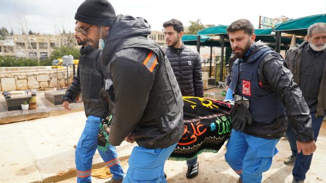 Colleagues carry the body during the funeral of two first aid responders and a third person, the day after they were killed in an Israeli airstrike, in the southern city of Nabatieh on March 25, 2026. Israel's attacks in Lebanon have killed more than 1,000 people, according to Lebanon's health ministry, and displaced more than a million people. On February 28, Israel and the United States launched strikes on Iran, killing its supreme leader and triggering a war that spread across the Middle East, with Lebanon's Hezbollah entering the fray on March 2. (Photo by Abbas Fakih / AFP)
