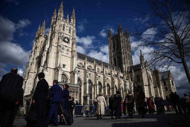 People arrive outside Canterbury Cathedral ahead of the installation ceremony for Archbishop of Canterbury Sarah Mullally in Canterbury, south-east England on March 25, 2026. The Church of England became Britain's state establishment church following King Henry VIII's split from the Roman Catholic Church in the 1530s. The British monarch is its supreme governor, while the Archbishop of Canterbury is seen as the spiritual leader of Anglicans worldwide. (Photo by Henry Nicholls / AFP)