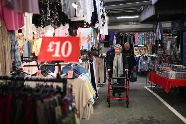 Shoppers make their way around various stalls at Bury Market in Bury, Greater Manchester on March 25, 2026. Britain's annual inflation rate was unchanged at 3.0 percent in February, official data showed on March 25 ahead of an expected jump as the Middle East war has sent oil prices surging. (Photo by Oli SCARFF / AFP)