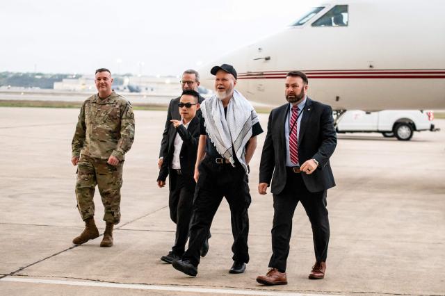 Dennis Coyle (2R) arrives at Kelly Field at Joint Base San Antonio in San Antonio, Texas, on March 25, 2026. Afghanistan's Taliban government released Coyle, a US national, on March 24 after being detained for more than a year, after a letter from his family requesting his freedom. The foreign ministry said the family of linguist and researcher Dennis Coyle had written to the supreme leader of Afghanistan, asking that he be freed and pardoned for Eid. (Photo by SERGIO FLORES / AFP)