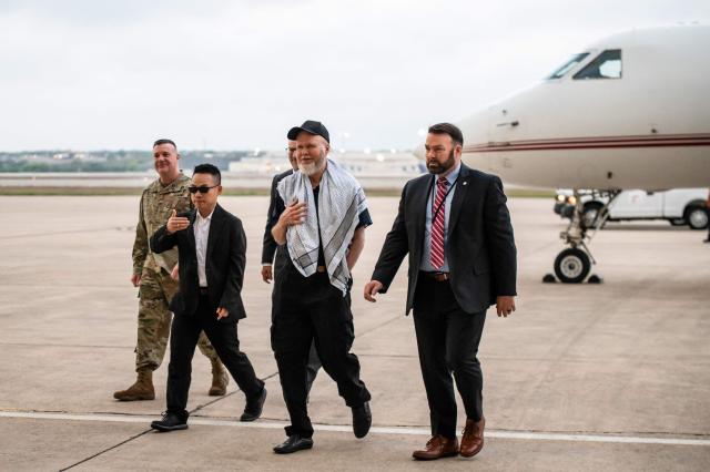 Dennis Coyle (2R) arrives at Kelly Field at Joint Base San Antonio in San Antonio, Texas, on March 25, 2026. Afghanistan's Taliban government released Coyle, a US national, on March 24 after being detained for more than a year, after a letter from his family requesting his freedom. The foreign ministry said the family of linguist and researcher Dennis Coyle had written to the supreme leader of Afghanistan, asking that he be freed and pardoned for Eid. (Photo by SERGIO FLORES / AFP)