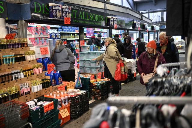 Shoppers make their way around various stalls at Bury Market in Bury, Greater Manchester on March 25, 2026. Britain's annual inflation rate was unchanged at 3.0 percent in February, official data showed on March 25 ahead of an expected jump as the Middle East war has sent oil prices surging. (Photo by Oli SCARFF / AFP)