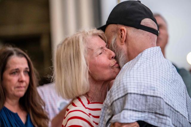 Dennis Coyle (R) embraces his mother as he arrives at Kelly Field at Joint Base San Antonio in San Antonio, Texas, on March 25, 2026. Afghanistan's Taliban government released Coyle, a US national, on March 24 after being detained for more than a year, after a letter from his family requesting his freedom. The foreign ministry said the family of linguist and researcher Dennis Coyle had written to the supreme leader of Afghanistan, asking that he be freed and pardoned for Eid. (Photo by SERGIO FLORES / AFP)