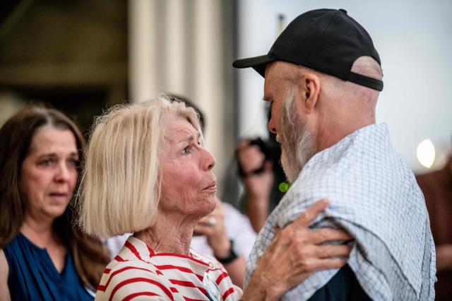 Dennis Coyle (R) embraces his mother as he arrives at Kelly Field at Joint Base San Antonio in San Antonio, Texas, on March 25, 2026. Afghanistan's Taliban government released Coyle, a US national, on March 24 after being detained for more than a year, after a letter from his family requesting his freedom. The foreign ministry said the family of linguist and researcher Dennis Coyle had written to the supreme leader of Afghanistan, asking that he be freed and pardoned for Eid. (Photo by SERGIO FLORES / AFP)