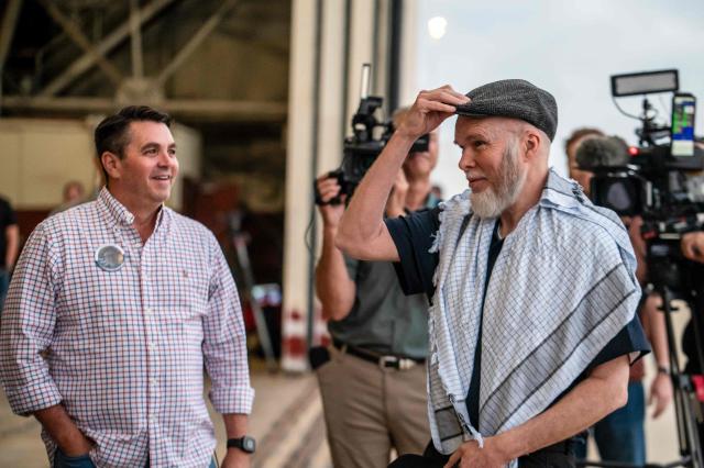 Dennis Coyle (R) speaks with family and friends as he arrives at Kelly Field at Joint Base San Antonio in San Antonio, Texas, on March 25, 2026. Afghanistan's Taliban government released Coyle, a US national, on March 24 after being detained for more than a year, after a letter from his family requesting his freedom. The foreign ministry said the family of linguist and researcher Dennis Coyle had written to the supreme leader of Afghanistan, asking that he be freed and pardoned for Eid. (Photo by SERGIO FLORES / AFP)