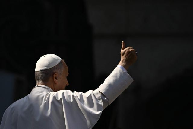 Pope Leo XIV pushes a thumb up as he leaves at the end of the weekly general audience at St Peter's Square in The Vatican on March 25, 2026. (Photo by Filippo MONTEFORTE / AFP)