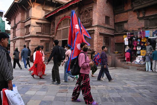 A vendor sells Nepal's national flags at Durbar Square in Kathmandu on March 25, 2026. (Photo by PRAKASH MATHEMA / AFP)