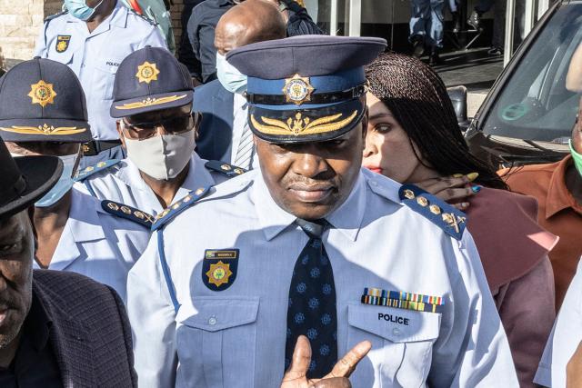 (FILES) South Africa's National Police Commissioner Fannie Masemola (C) stands next to unseen South African Minister of Police Bheki Cele while addressing members of the media outside the Police Station in Diepsloot, South Africa, on April 6, 2022. South African prosecutors said on March 25, 2026 they intend to charge the head of police over a $20-million health tender, in a case that has rocked the country and pulled in a dozen other officers. 
National Police Commissioner Fannie Masemola has been served with a summons to appear in court next month, said Kaizer Kganyago, spokesman for South Africa's National Prosecuting Authority. (Photo by GUILLEM SARTORIO / AFP) / ALTERNATE CROP