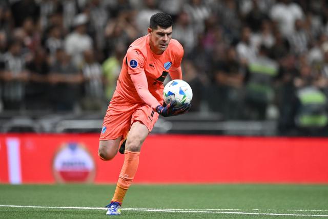 (FILES) Bolivar's goalkeeper #01 Carlos Lampe grabs the ball during the Copa Sudamericana quarterfinal second leg football match between Brazil's Atletico Mineiro and Bolivia's Bolivar at the Arena MRV Stadium in Belo Horizonte, Brazil on September 24, 2025. A collection of 54 football trading cards has become a sensation in Bolivia, featuring the national team players who traveled to Mexico with a single mission: to win the intercontinental playoff and return to the World Cup after 32 years. Each card is sold in a pack for five bolivianos (just over 50 US cents), but they are worth more than their price, as each sticker represents the hope of seeing La Verde back at a World Cup. (Photo by Gledston TAVARES / AFP)