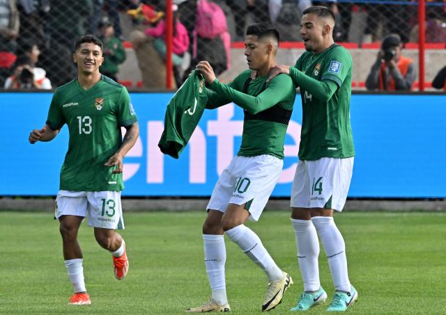 (FILES) Bolivia's forward Ramiro Vaca (C) celebrates with teammates midfielder Lucas Chavez (L) and midfielder Robson Matheus after scoring during the 2026 FIFA World Cup South American qualifiers football match between Bolivia and Venezuela, at the Municipal stadium, in El Alto, Bolivia, on September 5, 2024. A collection of 54 football trading cards has become a sensation in Bolivia, featuring the national team players who traveled to Mexico with a single mission: to win the intercontinental playoff and return to the World Cup after 32 years. Each card is sold in a pack for five bolivianos (just over 50 US cents), but they are worth more than their price, as each sticker represents the hope of seeing La Verde back at a World Cup. (Photo by AIZAR RALDES / AFP)