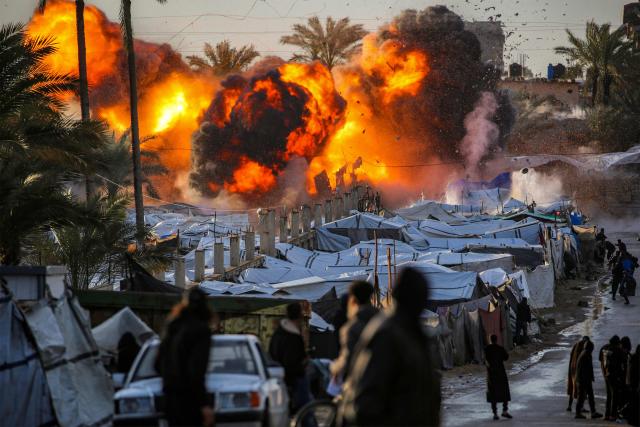 TOPSHOT - A fireball erupts following an Israeli strike near a tent encampment sheltering people displaced by war in Deir el-Balah in the central Gaza Strip on March 25, 2026. Violence has persisted in Gaza despite a ceasefire which came into effect on October 10, with both Israel and Hamas regularly accusing each other of violations. (Photo by Eyad Baba / AFP)