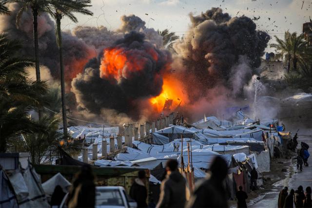 TOPSHOT - A fireball erupts following an Israeli strike near a tent encampment sheltering people displaced by war in Deir el-Balah in the central Gaza Strip on March 25, 2026. Violence has persisted in Gaza despite a ceasefire which came into effect on October 10, with both Israel and Hamas regularly accusing each other of violations. (Photo by Eyad Baba / AFP)