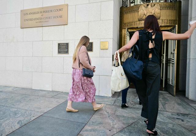Plaintiff "K.G.M." (L, in floral dress) arrives at Los Angeles Superior Court during the social media trial tasked to determine whether social media giants deliberately designed their platforms to be addictive to children, in Los Angeles, on March 25, 2026. Jurors resumed deliberations on March 24 in a landmark social media trial after signaling that they were having trouble agreeing when it comes to one of the two defendants, Meta and YouTube. (Photo by Frederic J. Brown / AFP)