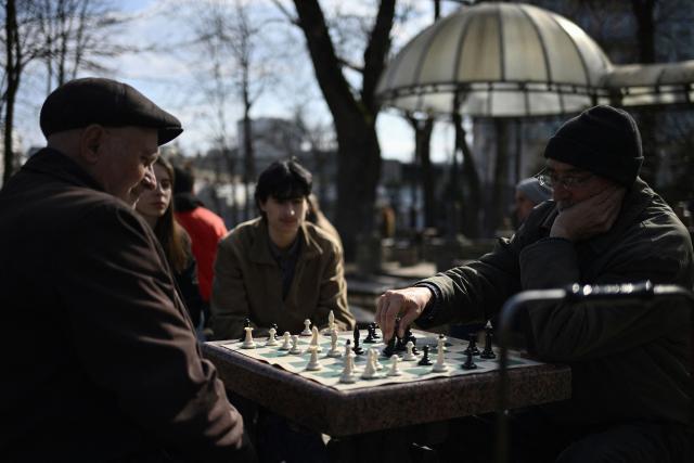 People play chess at a park in central Kyiv on March 25, 2026, amid the Russian invasion of Ukraine. (Photo by Genya SAVILOV / AFP)