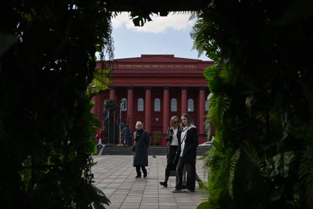 People walk past the Kyiv National University building in central Kyiv on March 25, 2026, amid the Russian invasion of Ukraine. (Photo by Genya SAVILOV / AFP)