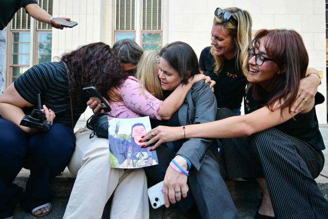 Laura Marquez-Garrett (3R), plaintiffs' attorney for SMVLC (Social Media Victims Law Center), gathers with family members of victims as they react to news that the jury has found Meta and YouTube liable in the social media addiction trial, outside the Los Angeles Superior Court , in Los Angeles, on March 25, 2026. (Photo by Frederic J. Brown / AFP)