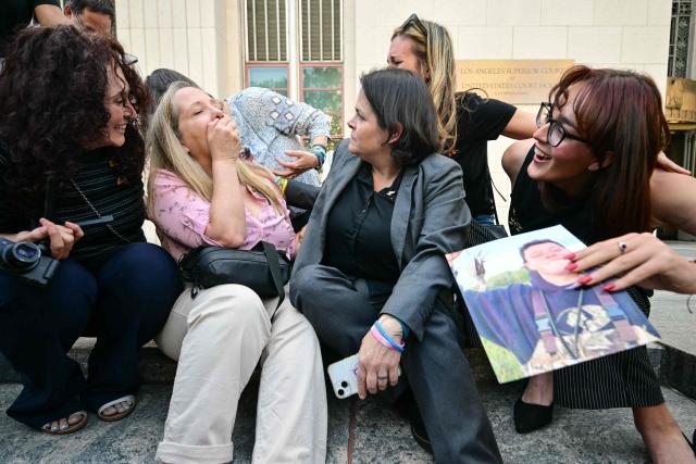 Laura Marquez-Garrett (C, gray blazer), plaintiffs' attorney for SMVLC (Social Media Victims Law Center), gathers with family members of victims as they react to news that the jury has found Meta and YouTube liable in the social media addiction trial, outside the Los Angeles Superior Court , in Los Angeles, on March 25, 2026. A Los Angeles jury on Wednesday found Meta and YouTube liable for harming a young woman through the addictive design of their social media platforms and ordered the companies to pay $3 million in damages. The decision delivering a landmark verdict that could reshape how the tech industry faces legal accountability for the mental health of young users. (Photo by Frederic J. Brown / AFP)