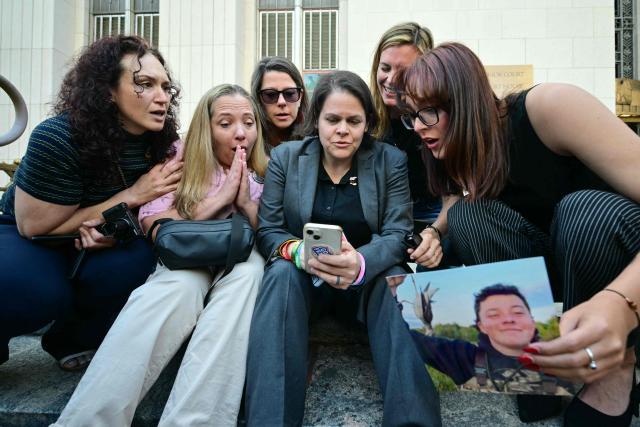 Laura Marquez-Garrett (C, gray blazer), plaintiffs' attorney for SMVLC (Social Media Victims Law Center), gathers with parents and family members of victims as they react to news that the jury has found Meta and YouTube liable in the social media addiction trial, outside the Los Angeles Superior Court , in Los Angeles, on March 25, 2026. A Los Angeles jury on Wednesday found Meta and YouTube liable for harming a young woman through the addictive design of their social media platforms and ordered the companies to pay $3 million in damages. The decision delivering a landmark verdict that could reshape how the tech industry faces legal accountability for the mental health of young users. (Photo by Frederic J. Brown / AFP)