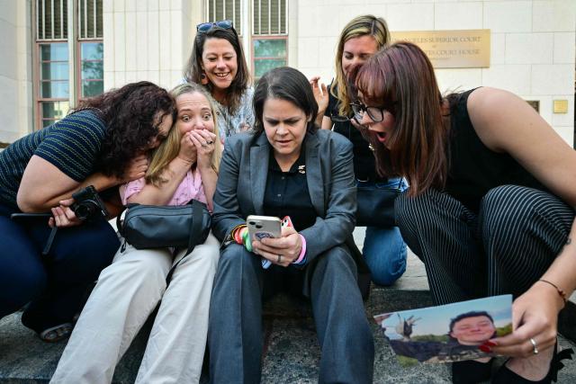 Laura Marquez-Garrett (C, gray blazer), plaintiffs' attorney for SMVLC (Social Media Victims Law Center), gathers with parents and family members of victims as they react to news that the jury has found Meta and YouTube liable in the social media addiction trial, outside the Los Angeles Superior Court , in Los Angeles, on March 25, 2026. A Los Angeles jury on Wednesday found Meta and YouTube liable for harming a young woman through the addictive design of their social media platforms and ordered the companies to pay $3 million in damages. The decision delivering a landmark verdict that could reshape how the tech industry faces legal accountability for the mental health of young users. (Photo by Frederic J. Brown / AFP)