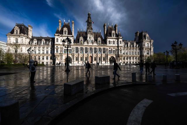 Pedestrians walk past the Hotel de Ville (Paris city hall) in Paris on March 25, 2026. (Photo by Blanca CRUZ / AFP)