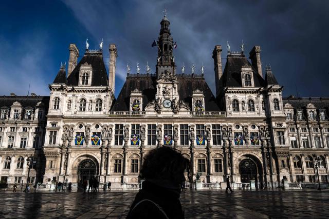 A pedestrian walks past the Hotel de Ville (Paris city hall) in Paris on March 25, 2026. (Photo by Blanca CRUZ / AFP)
