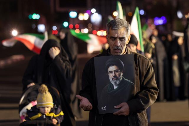 TOPSHOT - A man reacts as he holds a portrait of Iran's supreme leader Mojtaba Khamenei as people march in support of the Iranian armed forces in central Tehran on March 25, 2026. President Donald Trump is ready to "unleash hell" if Iran doesn't accept a deal to end the Middle East war, the White House warned on March 25, adding that talks continued despite Tehran reportedly rejecting a proposed US peace plan. (Photo by AFP) / 