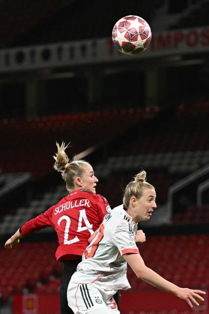 Manchester United's German forward #24 Lea Schuller (L) and Bayern Munich's German defender #30 Carolin Simon (R) fight for the ball in the air during the UEFA Women's Champions League, Quarter Final first-leg football match between Manchester United and Bayern Munich at Old Trafford in Manchester, north west England, on March 25, 2025. (Photo by Paul ELLIS / AFP)