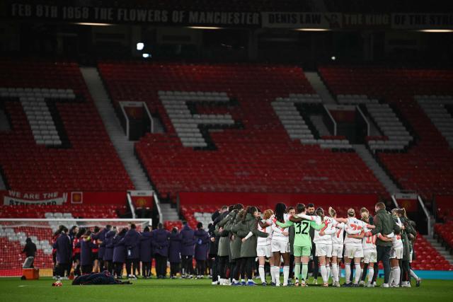 Bayern Munich's players (R) form a huddle as they celebrate their victory at the end of the UEFA Women's Champions League, Quarter Final first-leg football match between Manchester United and Bayern Munich at Old Trafford in Manchester, north west England, on March 25, 2025. (Photo by Paul ELLIS / AFP)