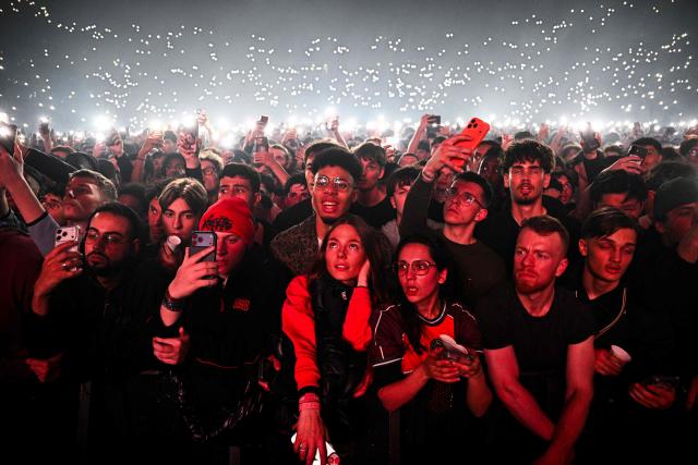 Fans cheer during a concert in tribute to late French rapper Werenoi at the Accor Arena in Paris on March 25, 2026. (Photo by JULIEN DE ROSA / AFP)