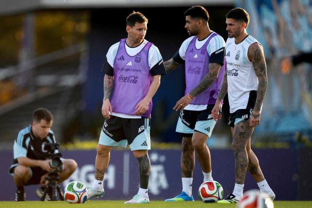 (L-R) Argentina's forward Lionel Messi, defender Cristian Romero, and midfielder Rodrigo De Paul talk during a training session in Ezeiza, Buenos Aires province, Argentina on March 25, 2026. Argentina will play a friendly match against Mauritania on March 27 at the La Bombonera Stadium in Buenos Aires. (Photo by Luis ROBAYO / AFP)