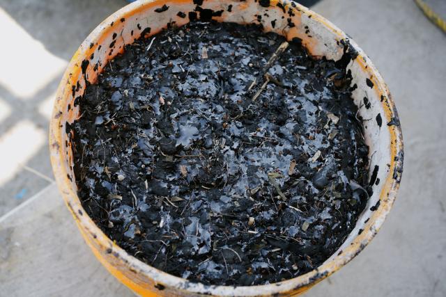 A bucket containing crude-oil-soaked debris is seen after being removed from a fishing pier in Boca del Rio, near Veracruz, Mexico, on March 25, 2026. The Mexican government said on March 25 that it has removed 128 tons of crude oil residue from the Gulf of Mexico following a spill first reported in early March. (Photo by Victoria Razo / AFP)