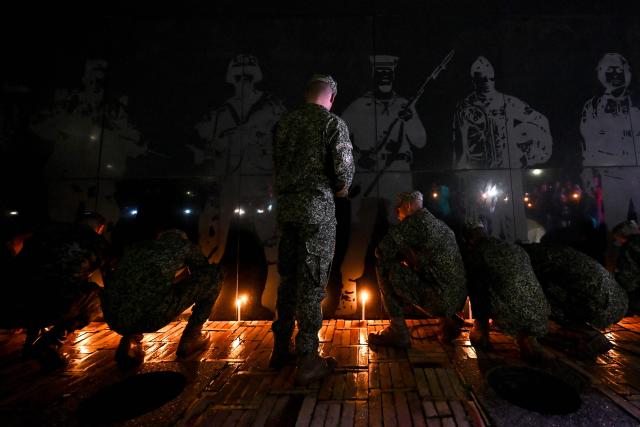 Colombian soldiers light candles at the Monument to the Fallen during a vigil for the victims of the Colombian Air Force Hercules crash in Puerto Leguizamo, in Bogota on March 25, 2026. At least 69 soldiers and police officers were killed in one of the deadliest air accidents in Colombia's recent history, according to a new March 24 tally of the crash, which the government attributed to a ‘junk’ aircraft donated by the United States. (Photo by Daniel MUNOZ / AFP)