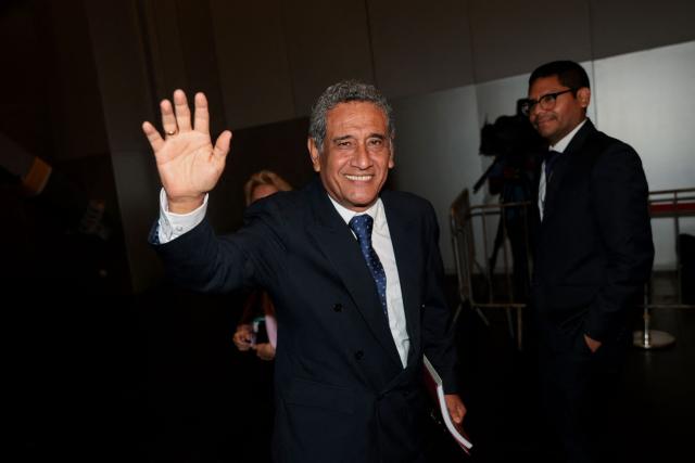 Peru's presidential candidate Mesias Guevara, for the Morado party, waves as he arrives at the third round of debates on tackling crime and corruption at the Lima Convention Center in Lima on March 25, 2026. Peru will hold presidential elections on April 12. (Photo by Connie FRANCE / AFP)