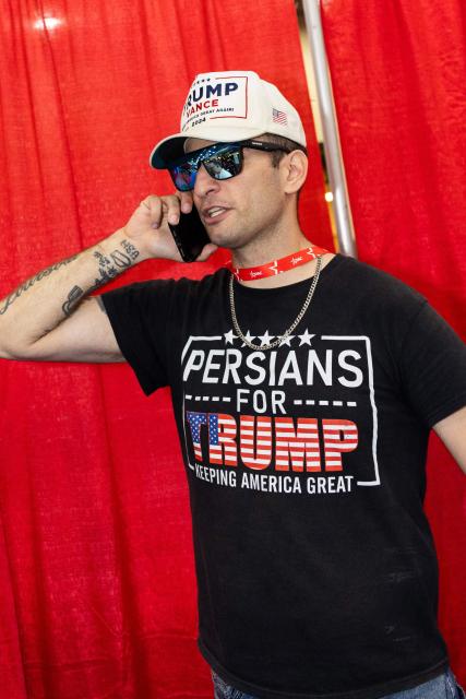 An attendee wears a “Persians for Trump” shirt at the Conservative Political Action Conference at the Gaylord Texan Resort & Convention Center, in Grapevine, Texas, on March 25, 2026. American conservatives converge on Texas this week for what organizers bill as their largest and most influential gathering, with the Iran war and fears of a punishing midterm election cycle heightening the stakes. (Photo by Leandro Lozada / AFP)