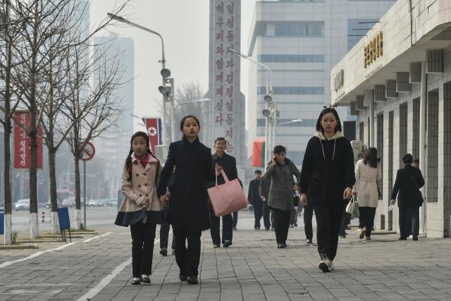People walk along Changjon Street in Pyongyang on March 25, 2026. (Photo by KIM Won Jin / AFP)