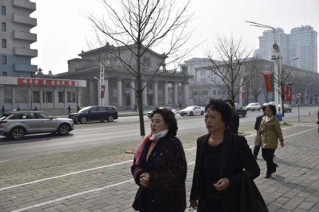 People walk along Changjon Street in Pyongyang on March 25, 2026. (Photo by KIM Won Jin / AFP)