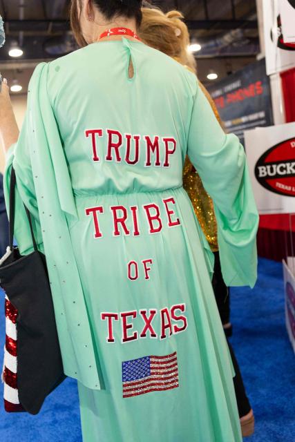 An attendee walks through the exhibition hall during the Conservative Political Action Conference, at the Gaylord Texan Resort & Convention Center, in Grapevine, Texas, on March 25, 2026. American conservatives converge on Texas this week for what organizers bill as their largest and most influential gathering, with the Iran war and fears of a punishing midterm election cycle heightening the stakes. (Photo by Leandro Lozada / AFP)