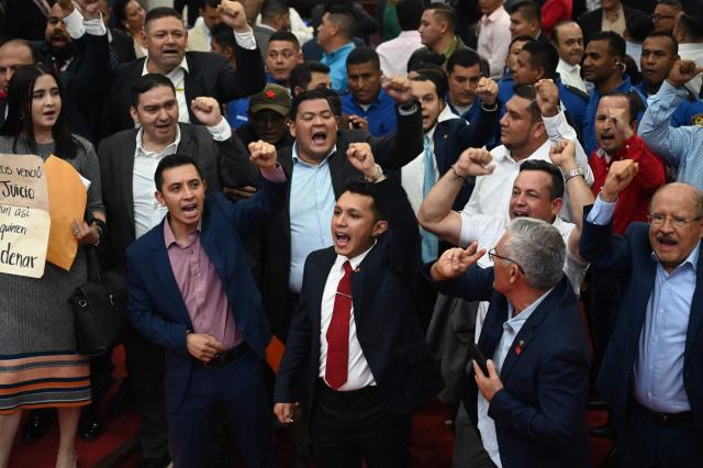 Lawmakers from the opposition Liberty and Refoundation (LIBRE) party protest against the election of Honduras’ new Attorney General, Pablo Emilio Reyes Theodore (out of frame), in Tegucigalpa on March 25, 2026. Honduras’ Congress, controlled by the right, suspended Attorney General Johel Zelaya on the night of March 23, 2026. Zelaya, who is close to the previous leftist government, was removed to face an impeachment trial on accusations of abuse of authority and persecution during last November’s elections. (Photo by Orlando SIERRA / AFP)