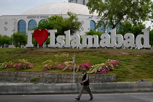 A man walks past the Diplomatic Enclave in Islamabad on March 26, 2026. Proposals from the United States to end the war in Iran have been sent to Tehran through Pakistani intermediaries, two senior officials in Islamabad told AFP on March 25. (Photo by Aamir QURESHI / AFP)
