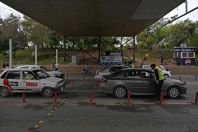 Traffic police personnel stand guard at a security check point in Islamabad on March 26, 2026. Proposals from the United States to end the war in Iran have been sent to Tehran through Pakistani intermediaries, two senior officials in Islamabad told AFP on March 25. (Photo by Aamir QURESHI / AFP)
